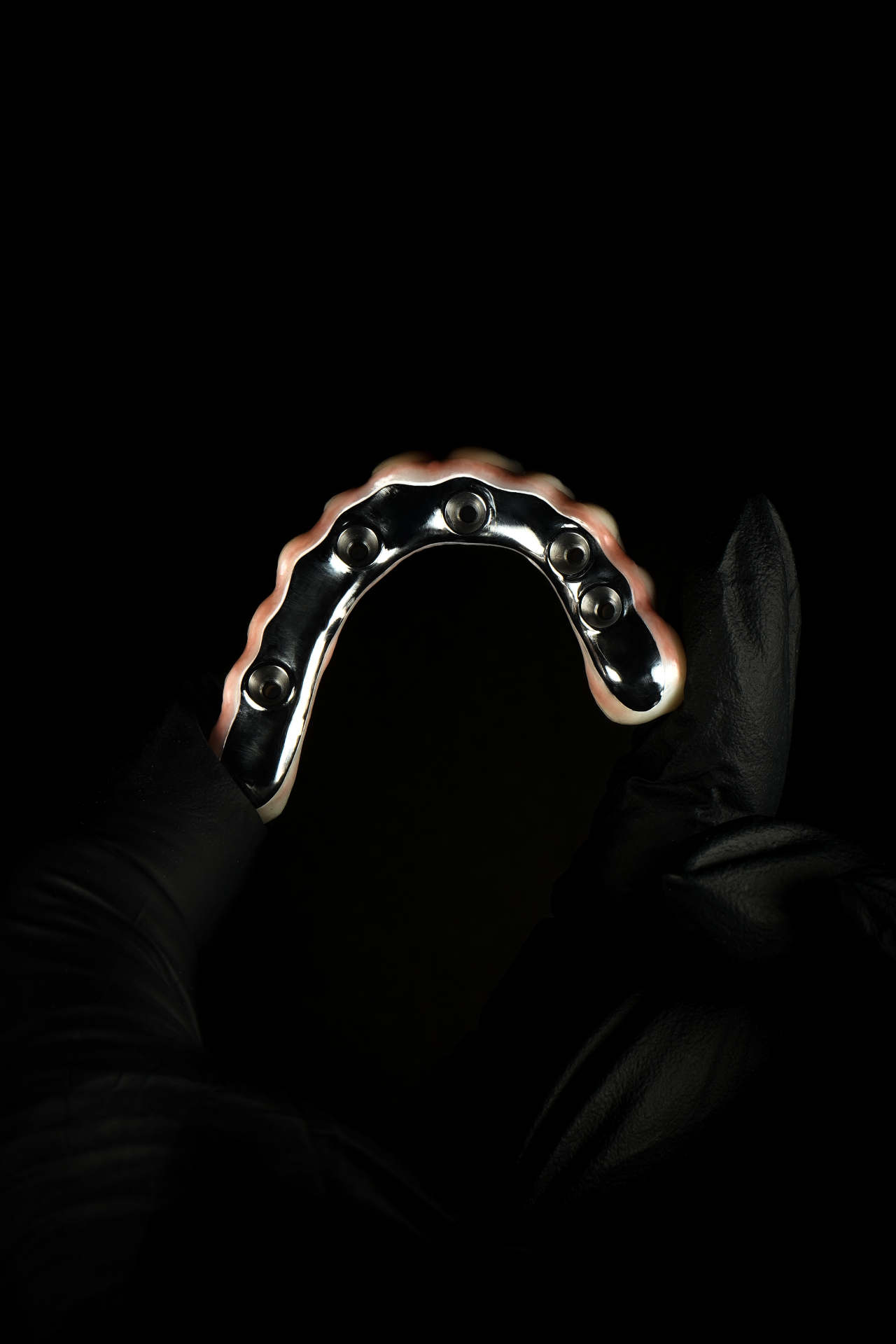 Titanium AOX framework held in gloved hand